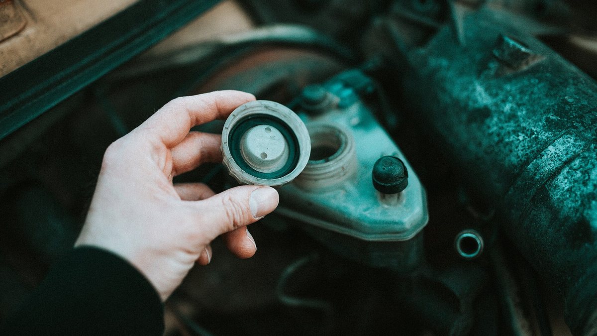 Checking the fluid level in a car engine during maintenance work