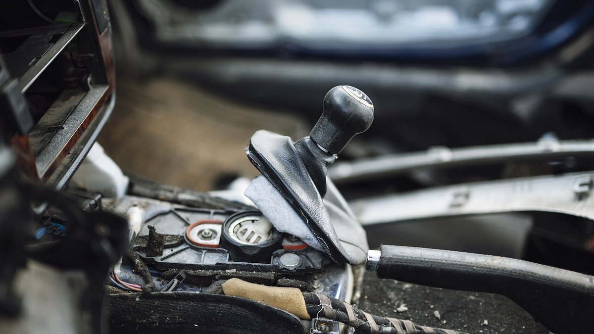 Car gear shift in an old vehicle interior showing signs of wear and tear during a repair session in an auto shop