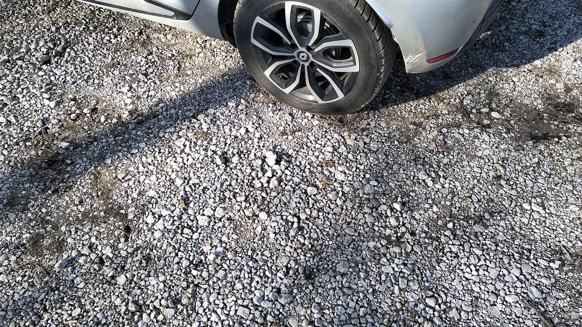 Gravel road, car in viewfield for scale