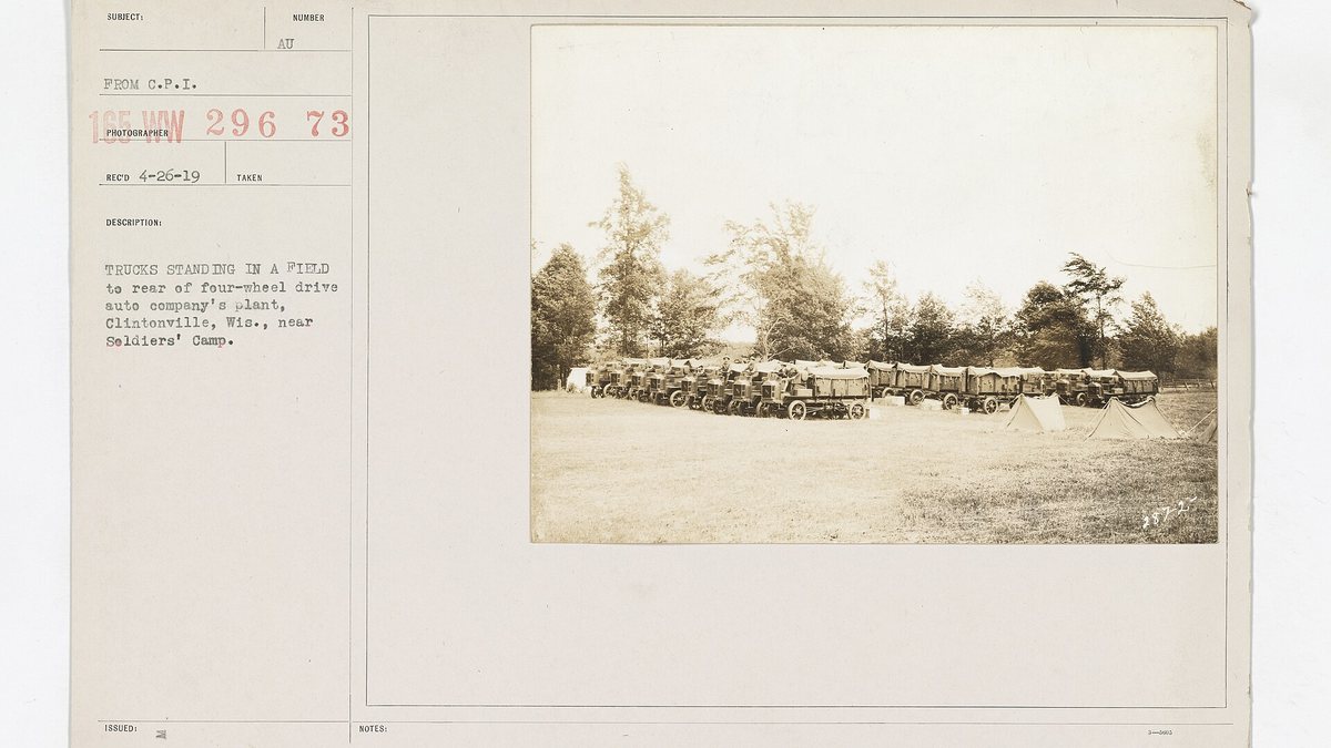 Motor Vehicles - Motor Trucks - In Use - Trucks standing in a field to rear of four-wheel drive auto company's plant, Clintonville, Wis., ne